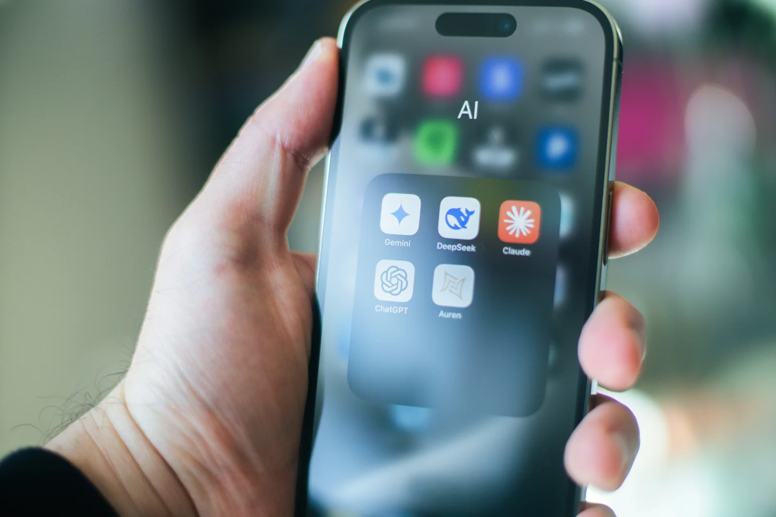 Handwerker fragt einen KI-Chatbot auf dem Smartphone nach einem Betrieb in seiner Region